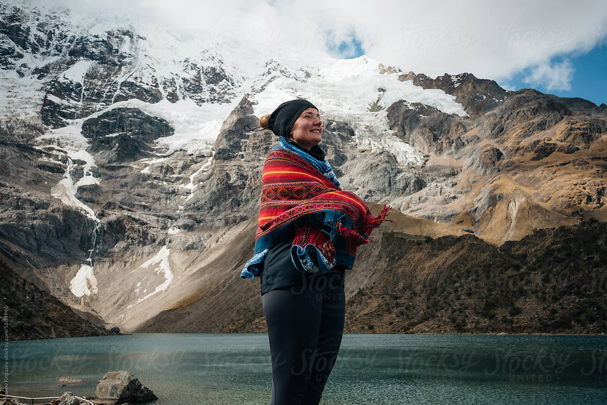 Woman Standing near a  Mountain lake wrapped in scarf