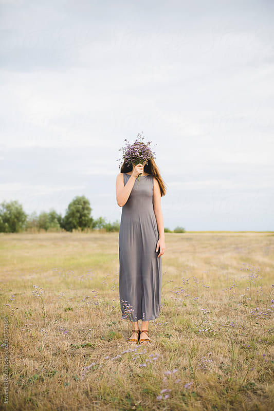 Young Woman Covering Her Face With Flower Bouquet By Jovana Rikalo Stocksy United