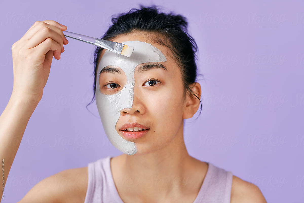 Young beautiful woman with mineral mask on her face