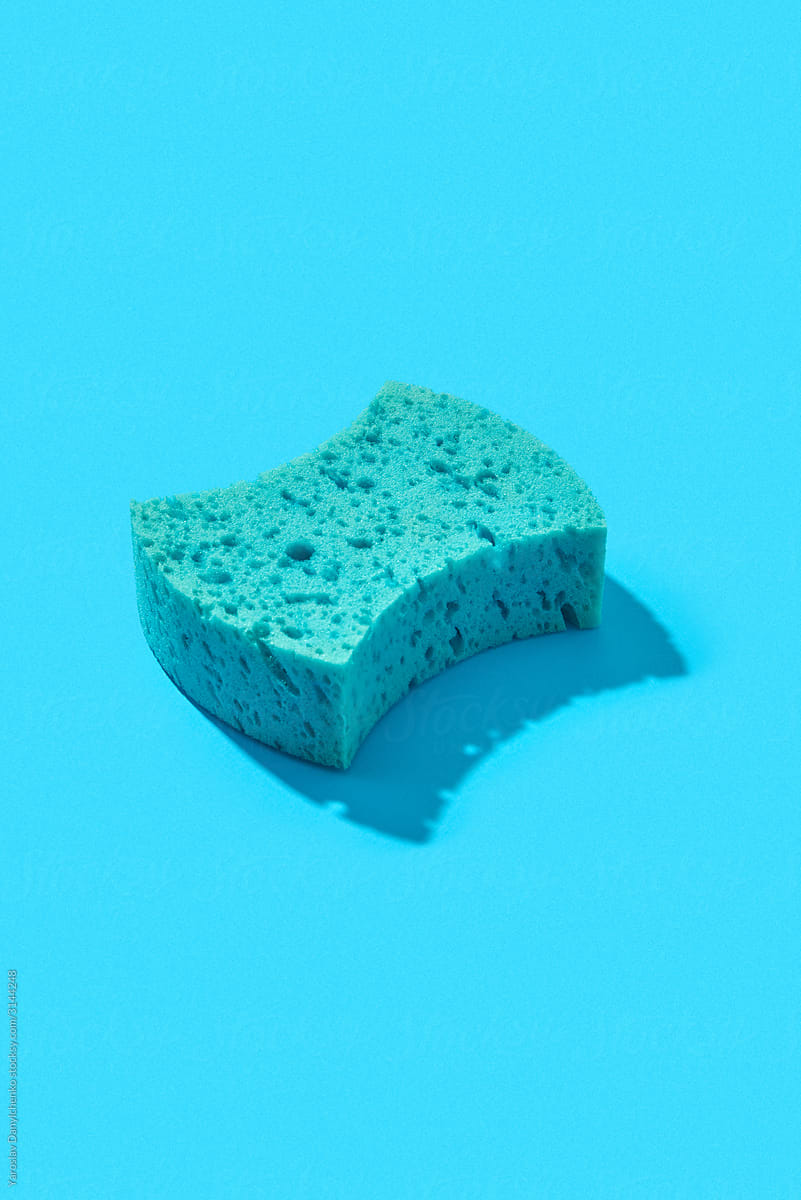 Blue bath sponge with hard shadow.