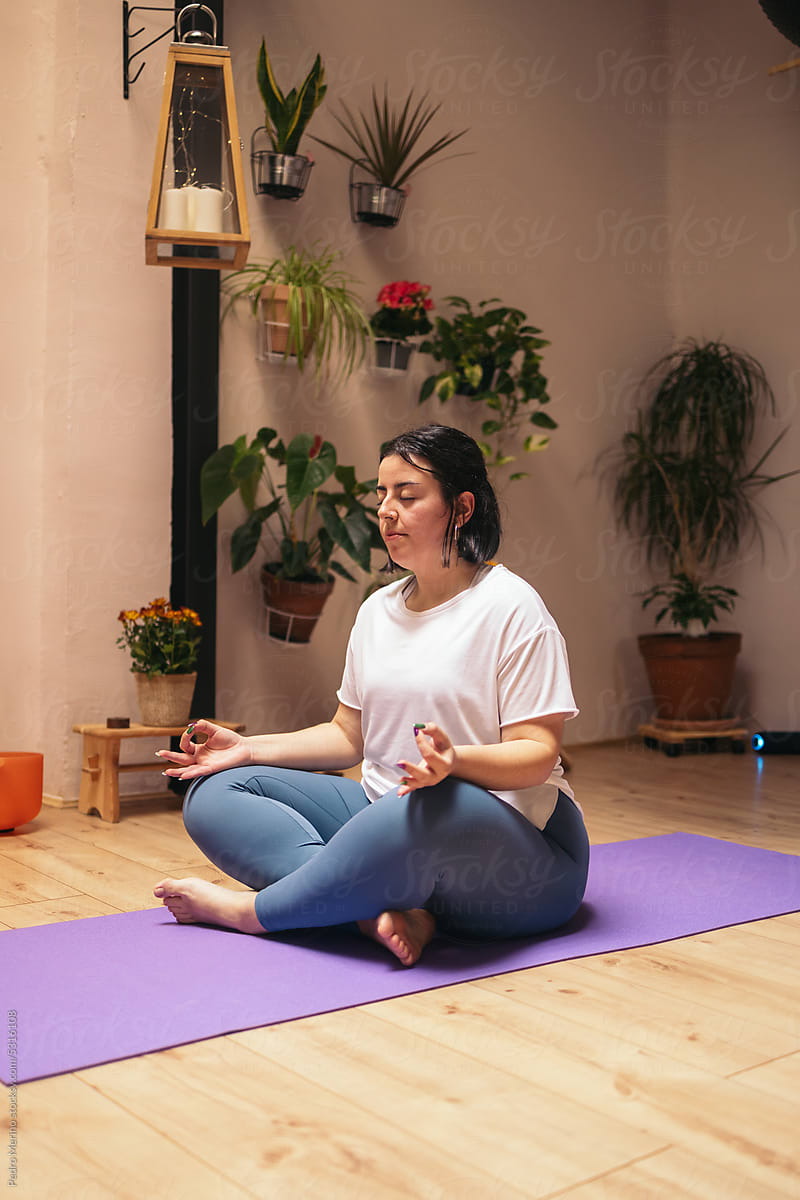 Woman meditating in a cozy room after a yoga class