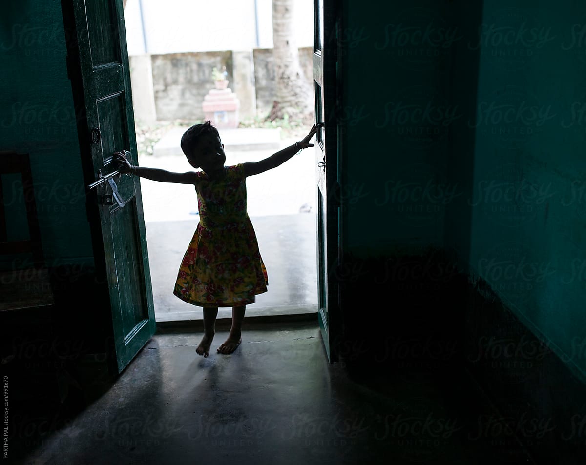 A little girl entering through a door