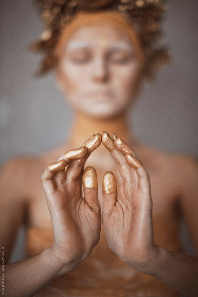 Closeup hands with golden paint on the fingers