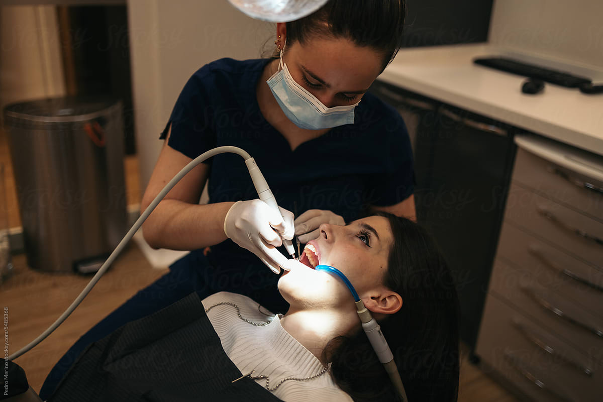 Dentist doing a dental cleaning to a patient
