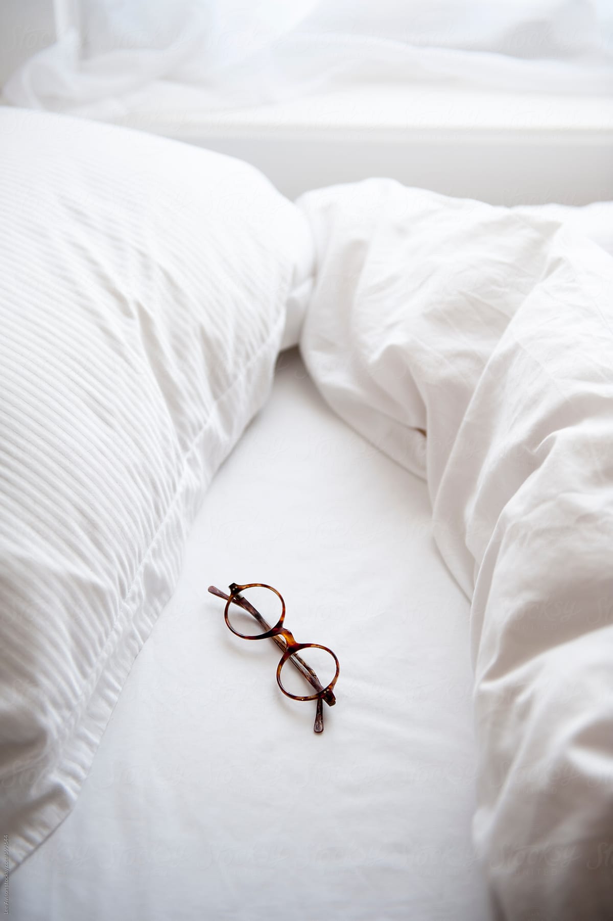 vintage spectacles on an unmade bed