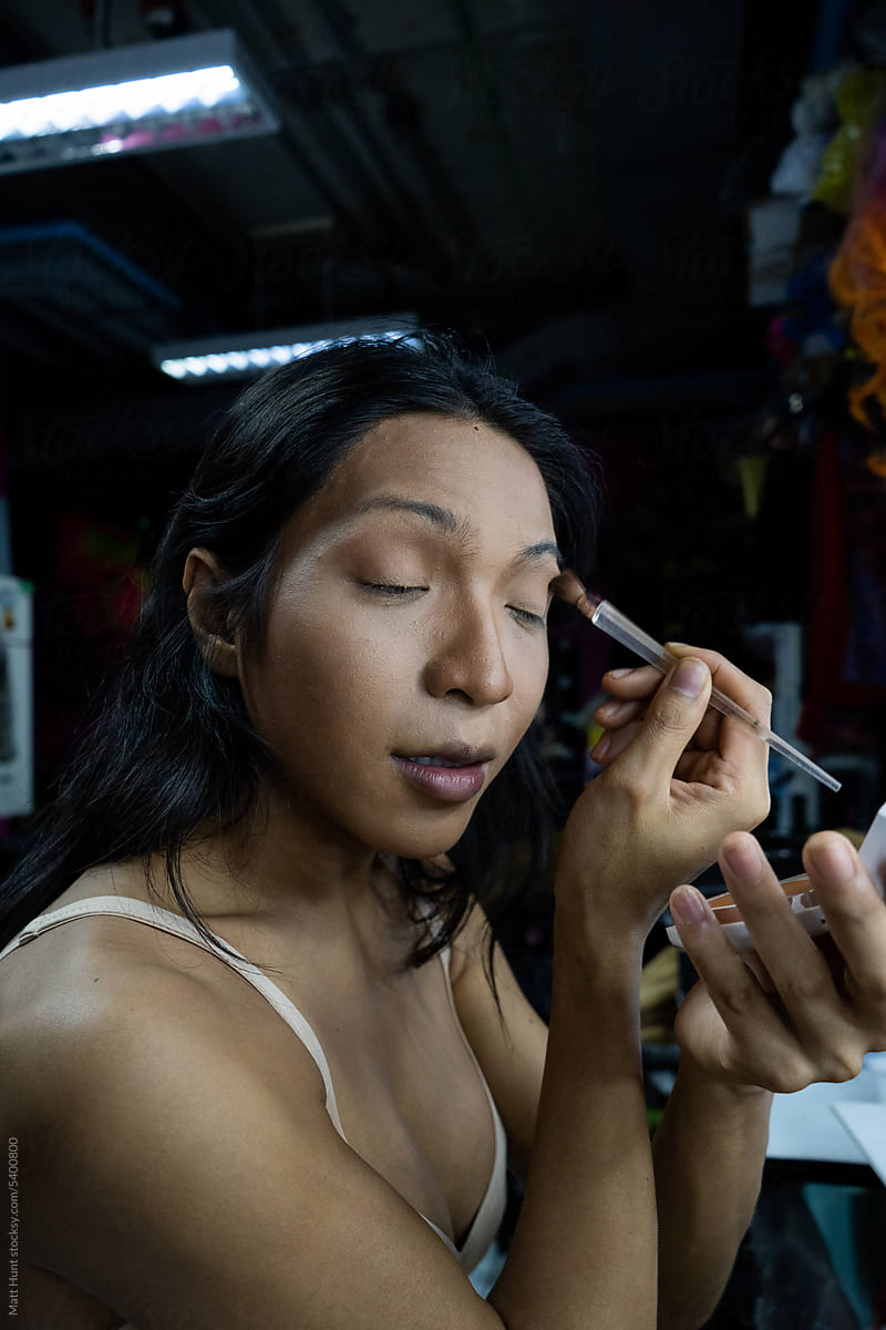 An LGBTQ performer does her eye makeup before a drag performance