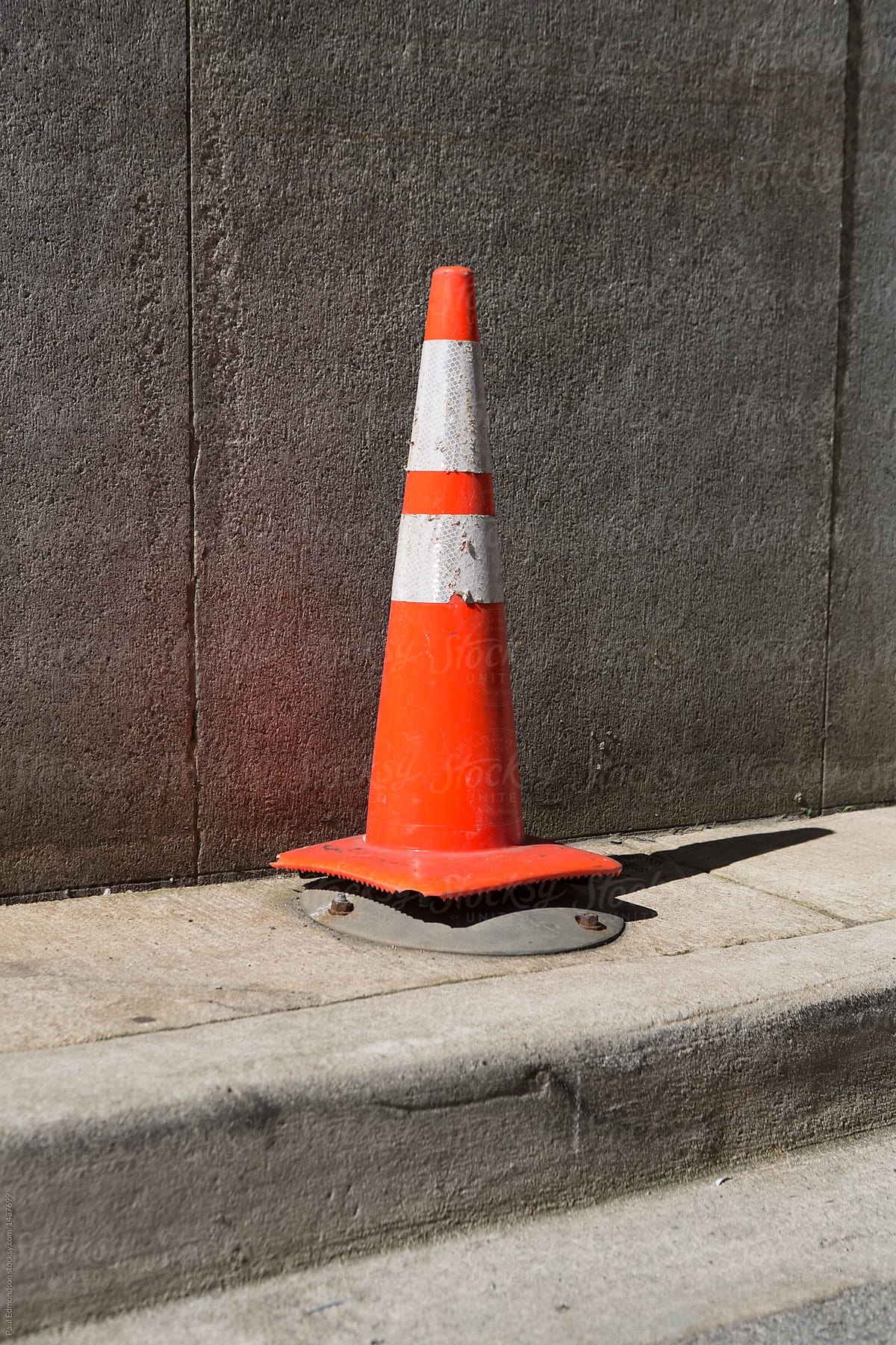 Traffic cone on urban sidewalk and street
