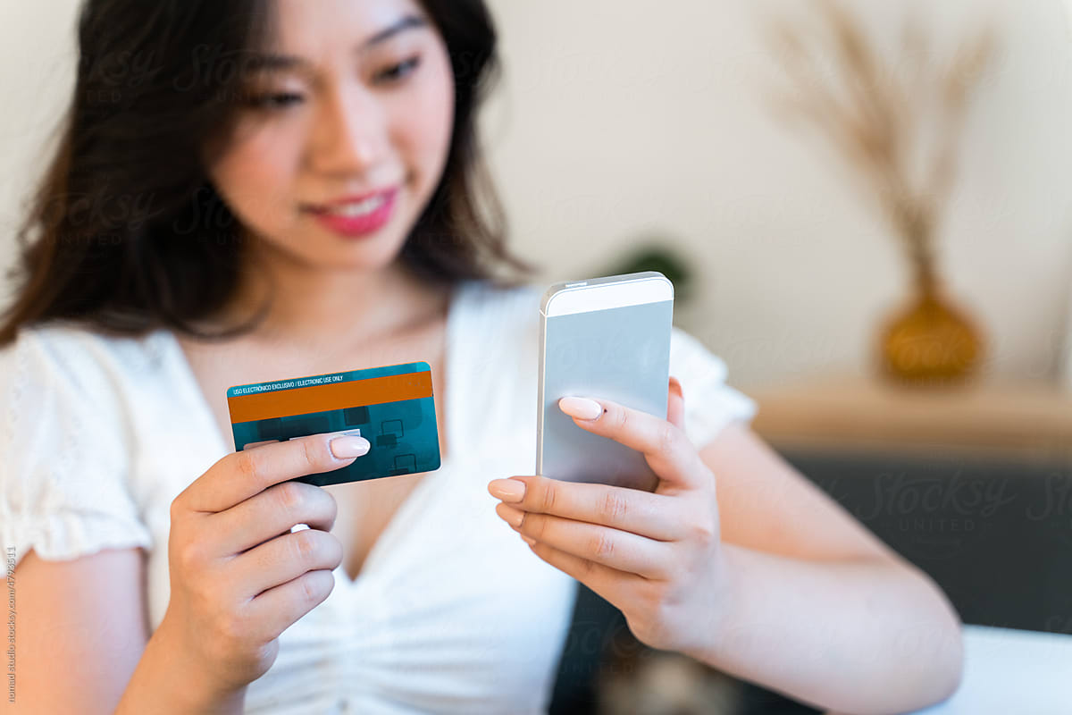 Woman holding a mobile phone and credit card.