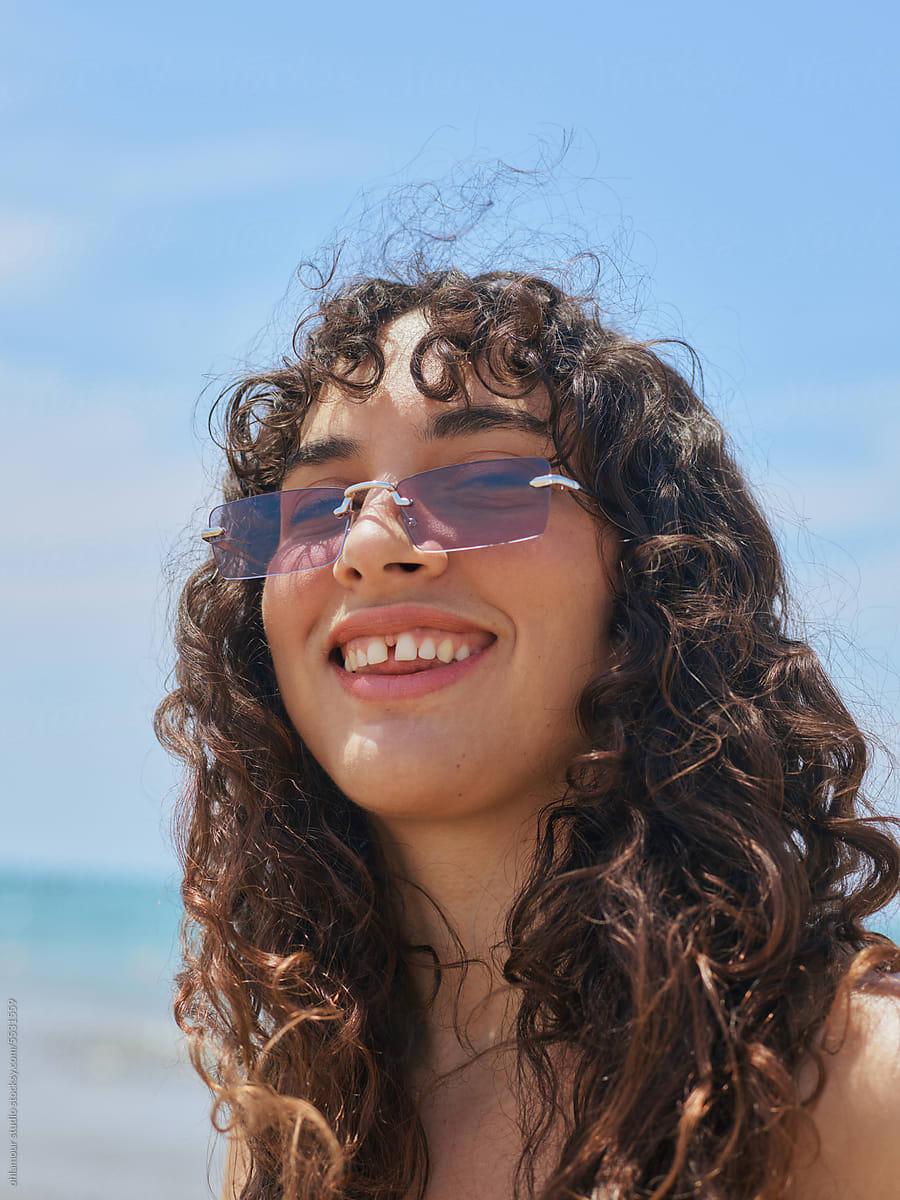 Sun, curls and Style on the seaside, woman smiling portrait