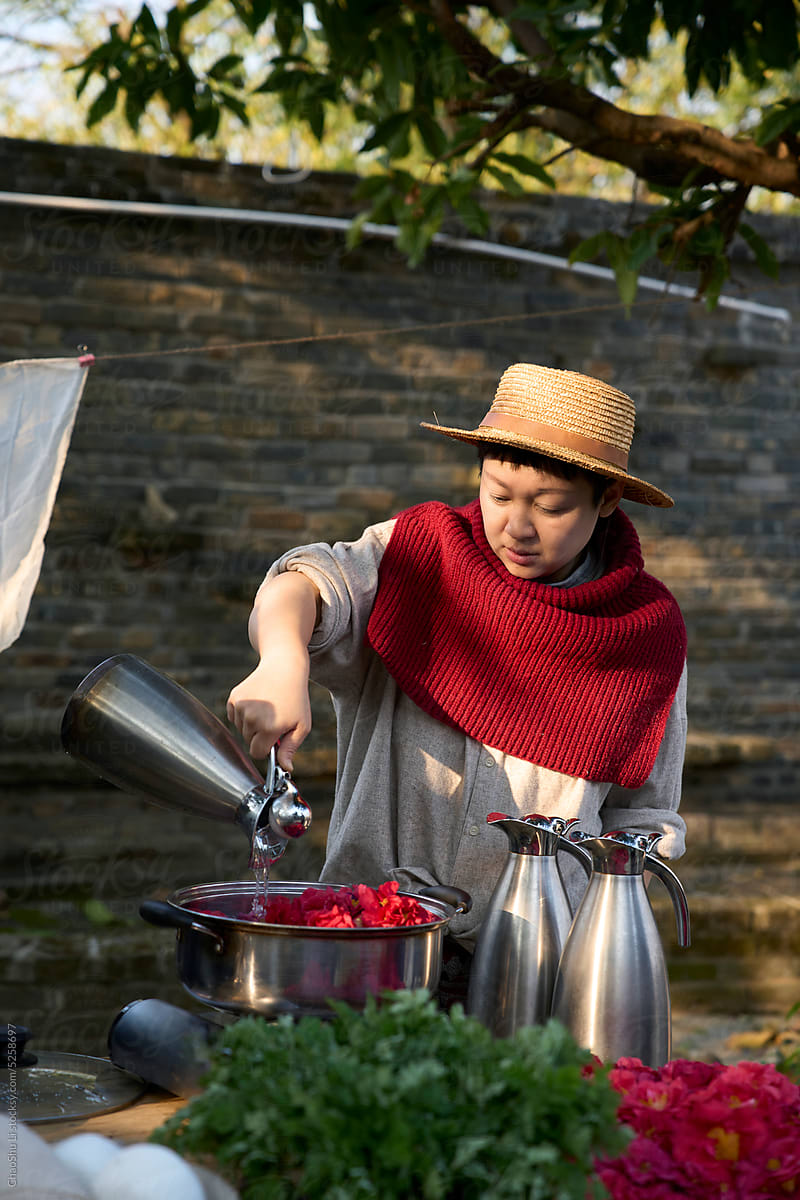 Asian lady is dyeing fabric into boiled dye water