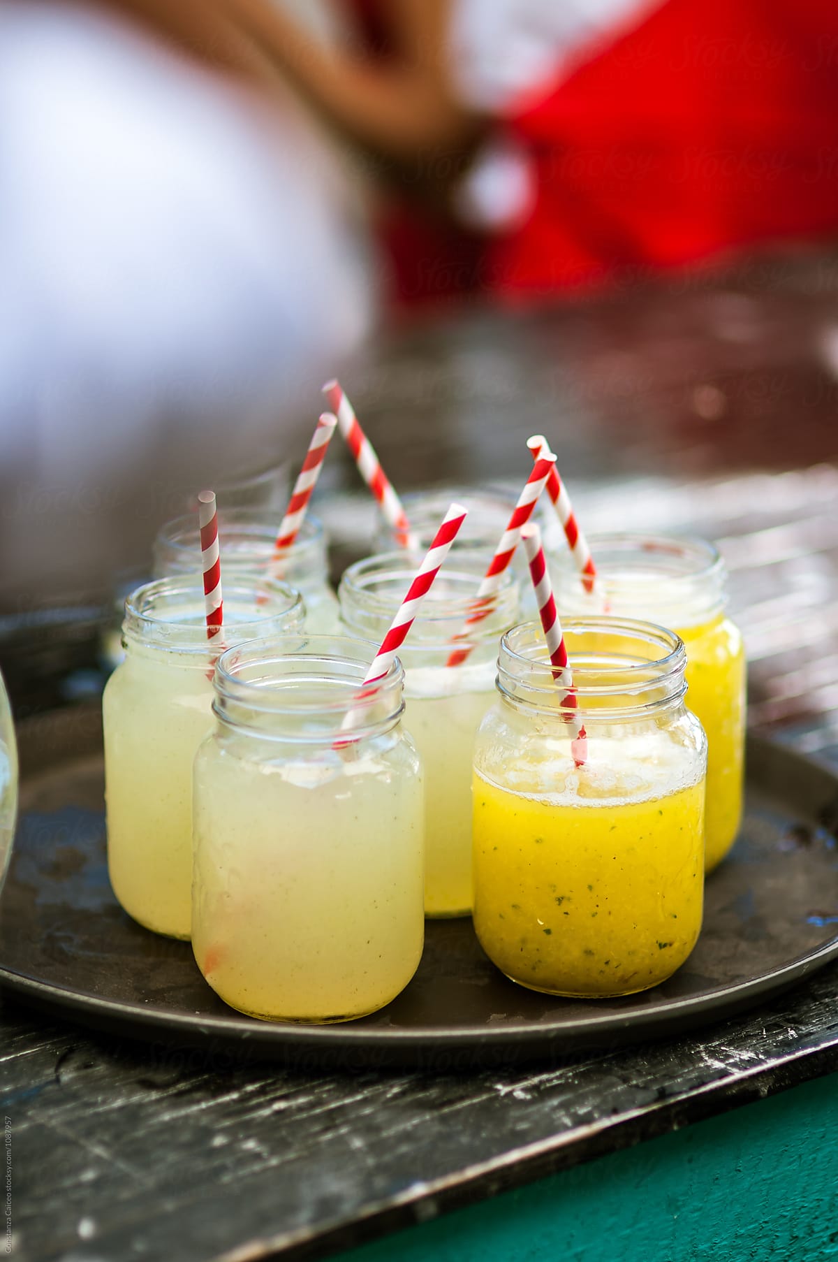 Lemonade jars on a tray with red and white stripped straws