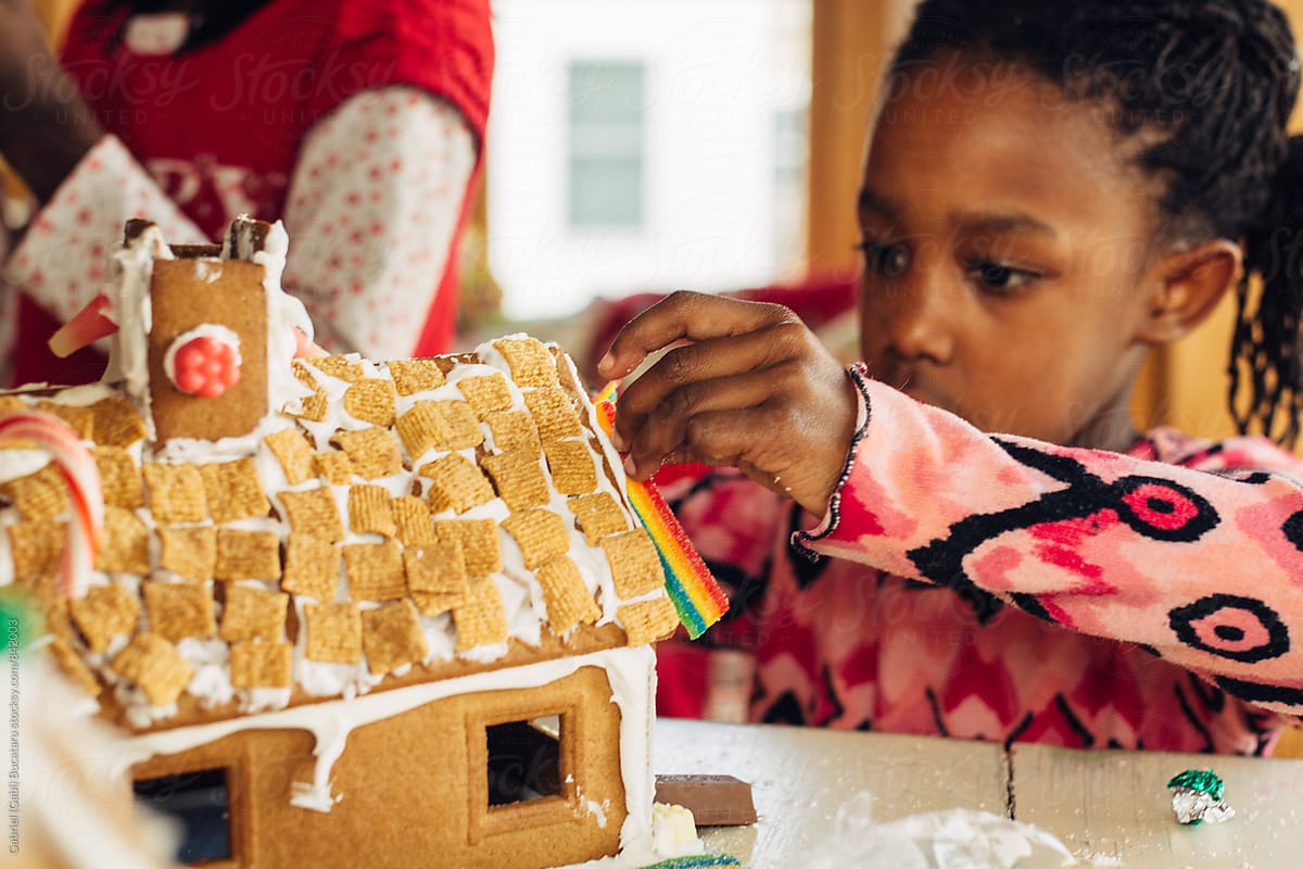 Young black girl working on a gingerbread house