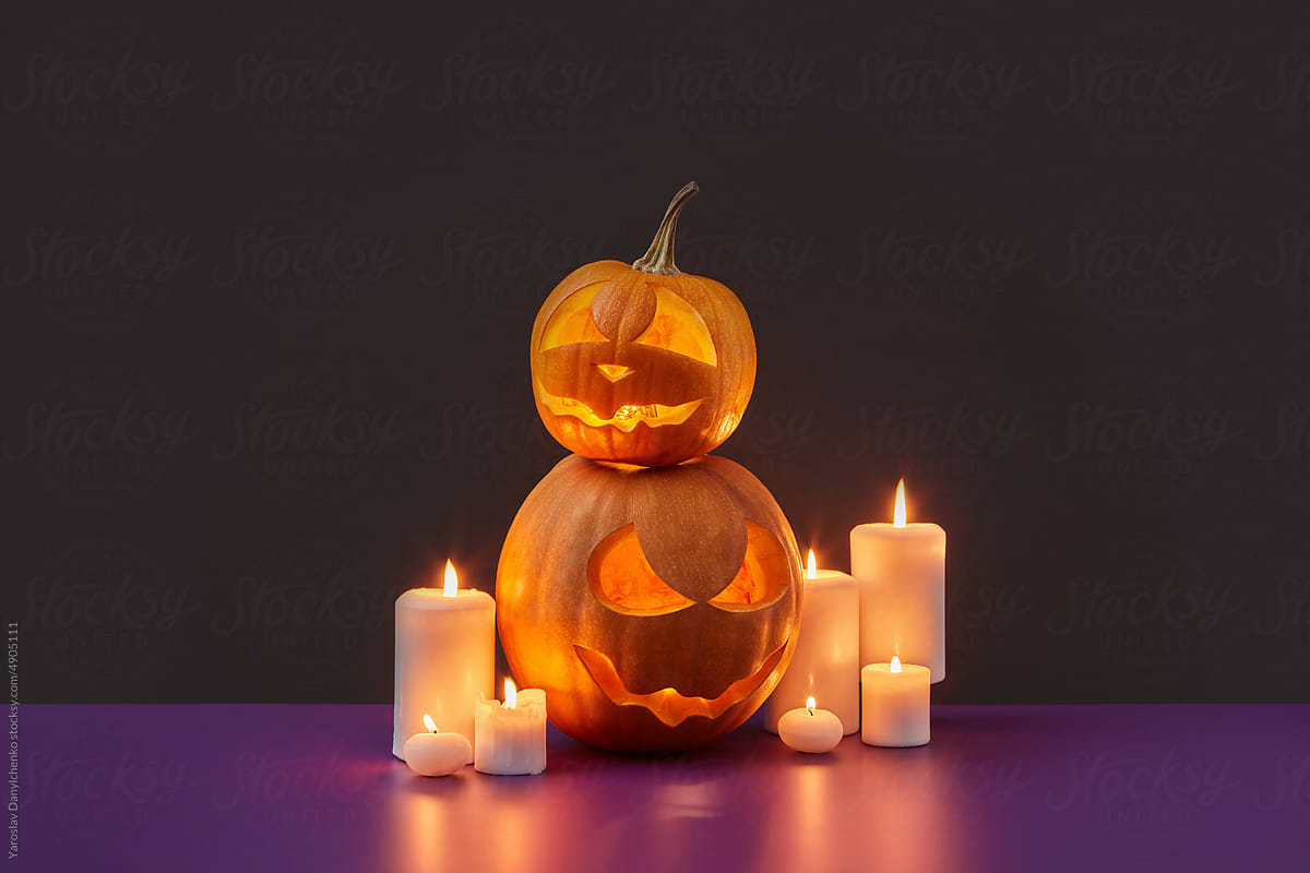 Glowing Halloween pumpkins with burning candles.