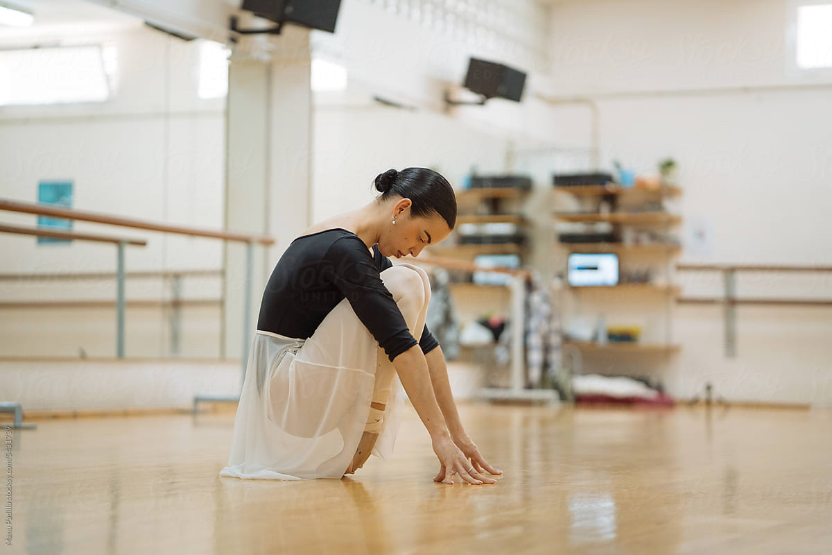 Slim ballet dancer practicing dance in spacious studio