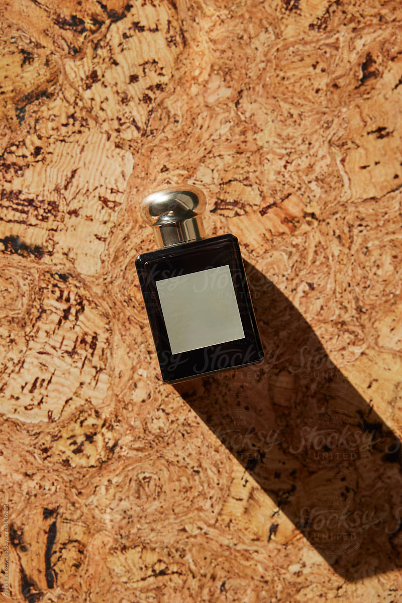 Black perfume bottle on cork surface