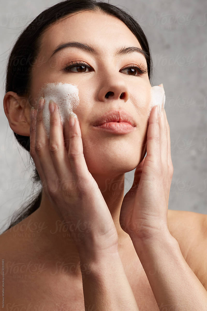 Mixed Race Asian Woman Applying Skincare Cleanser