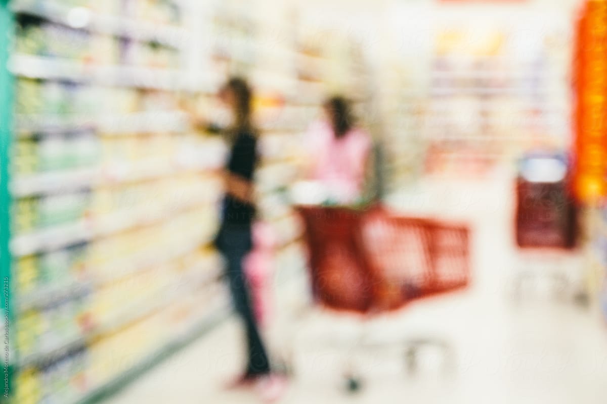 People on a supermarket with shopping carts - blurred image