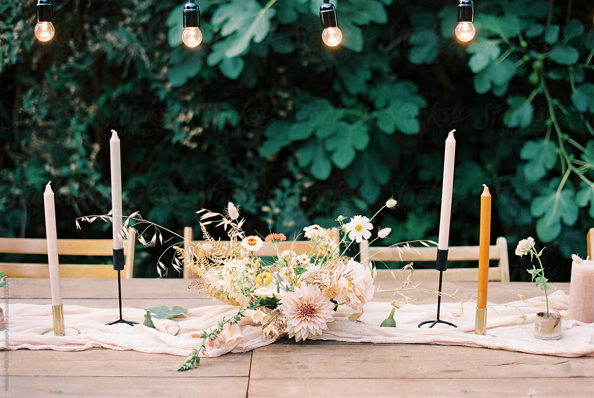 Styled outdoor wedding table with pastel flowers and candles