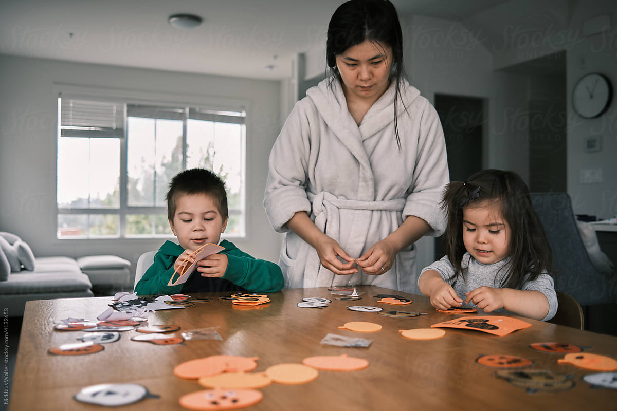 Young Asian Family Making Halloween Crafts Together.