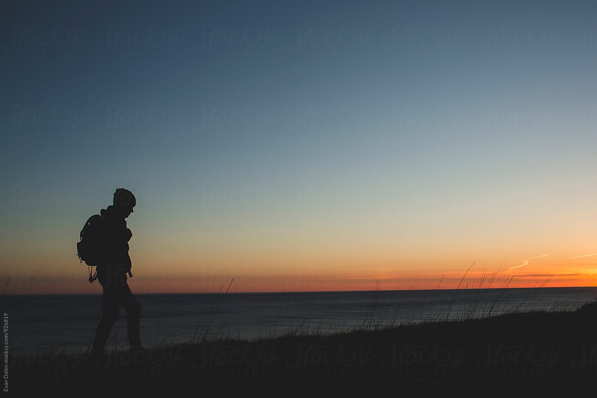 Hiker On Cliff At Sunset By Stocksy Contributor Evan Dalen Stocksy