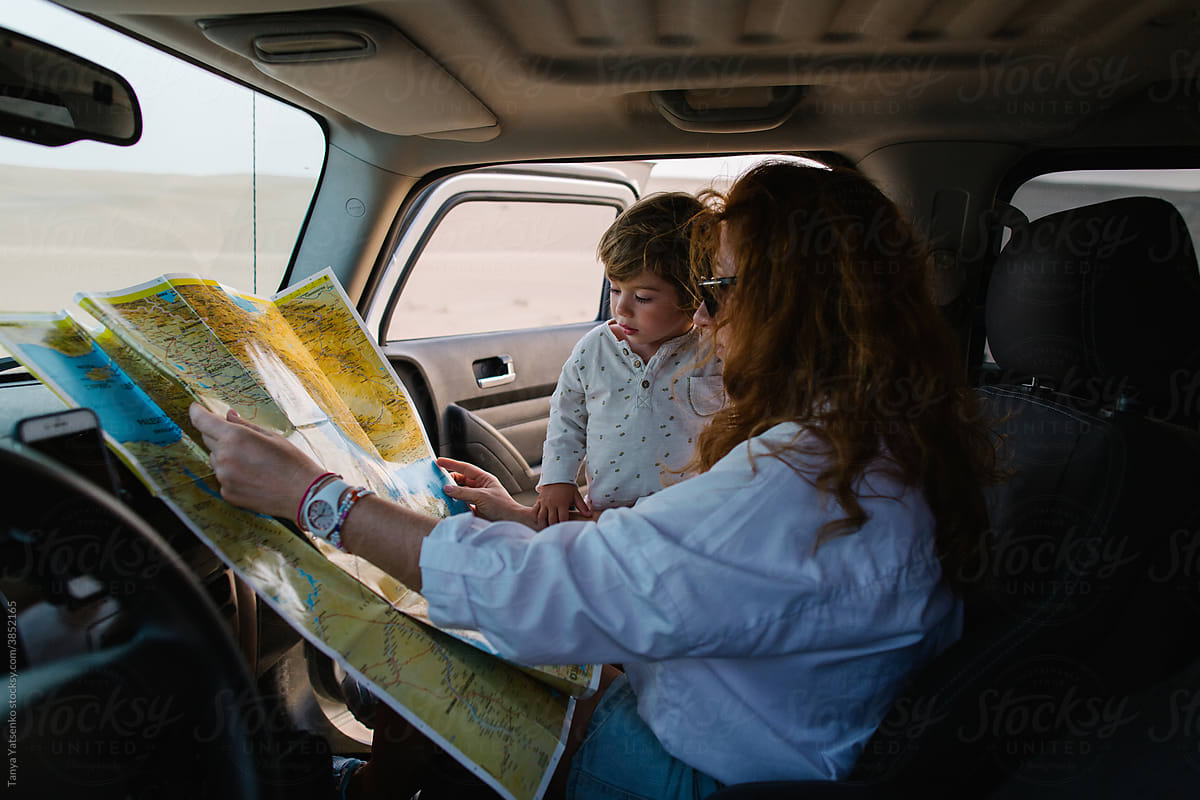 Mother and her son with a map in a car