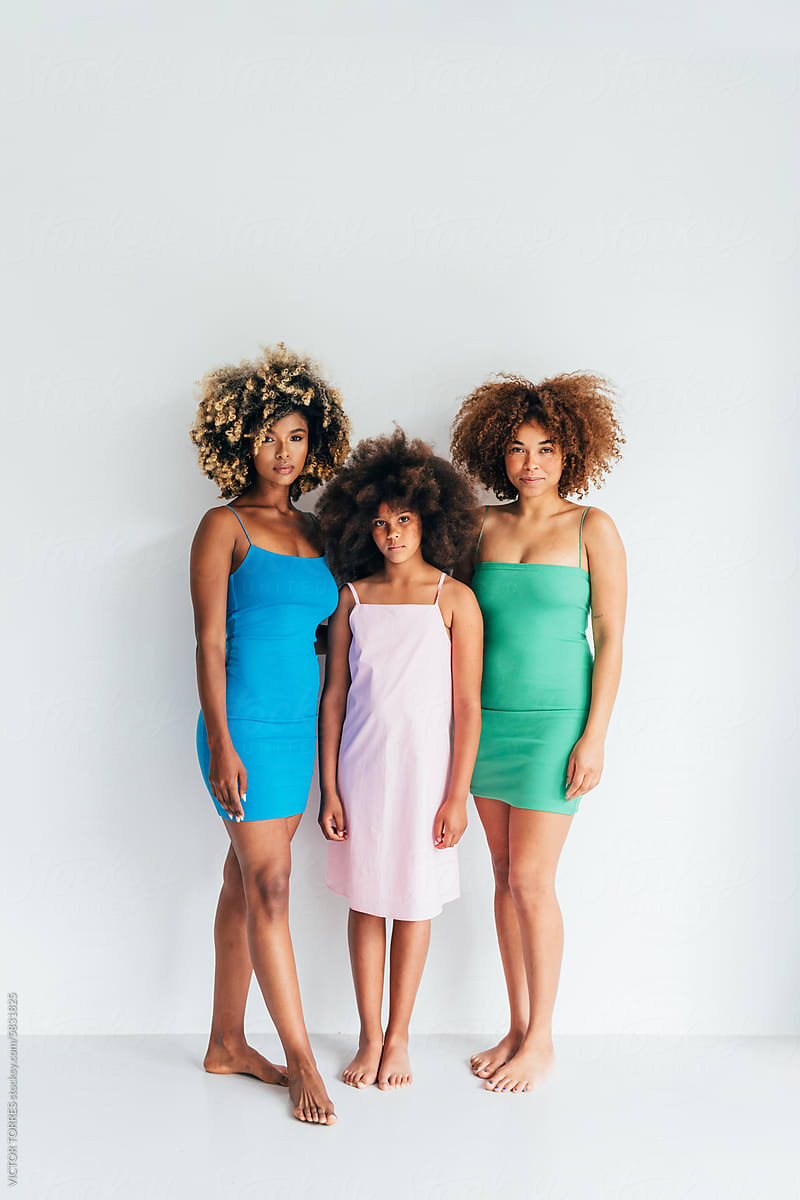 Three generations of black women in colorful dresses