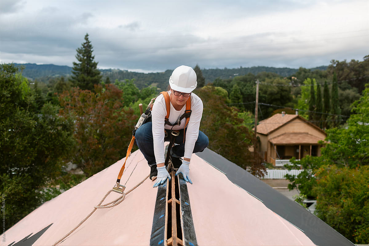 Woman roofing on house with gables in construction work