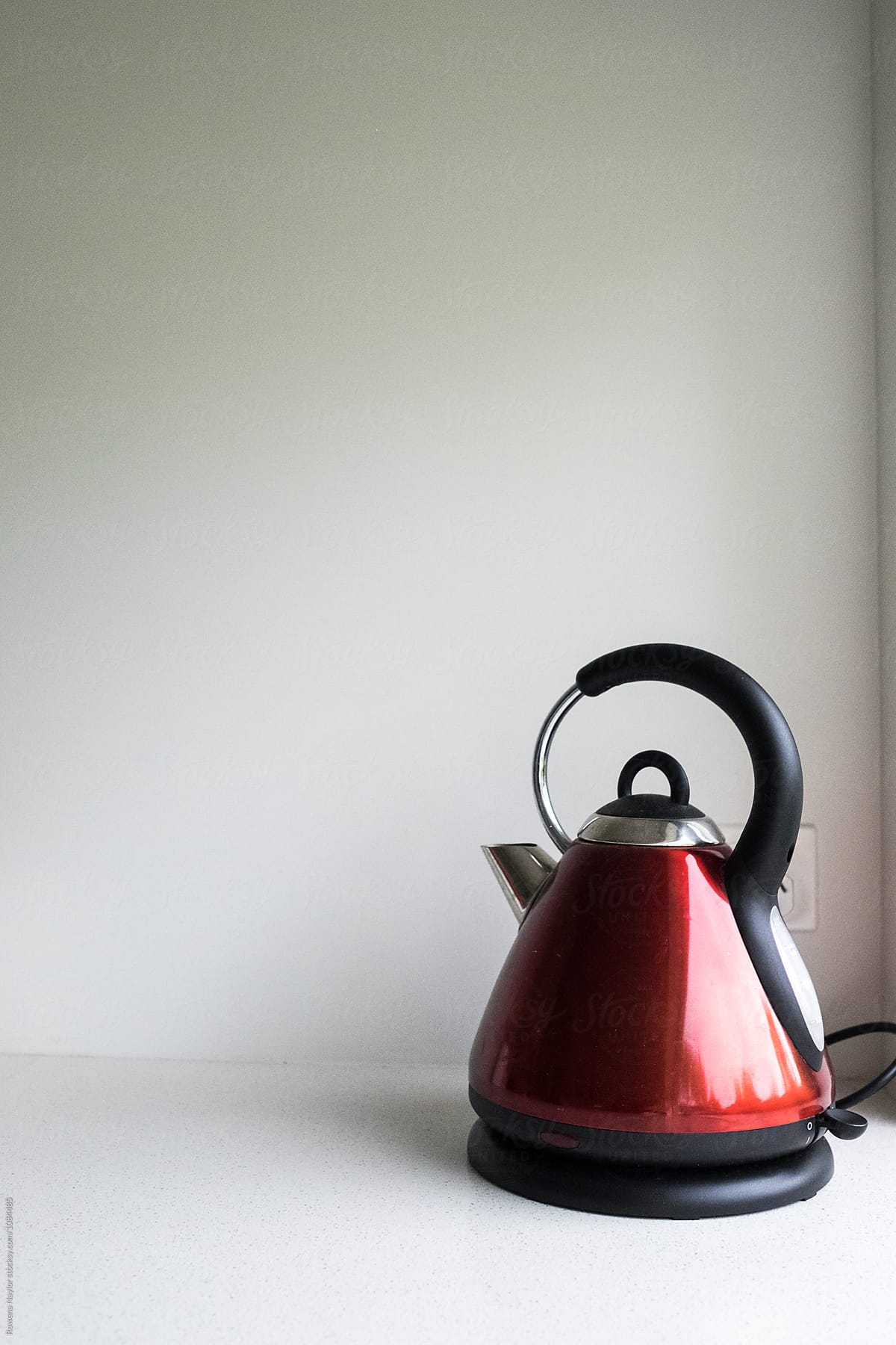 Red electric kettle on white kitchen benchtop