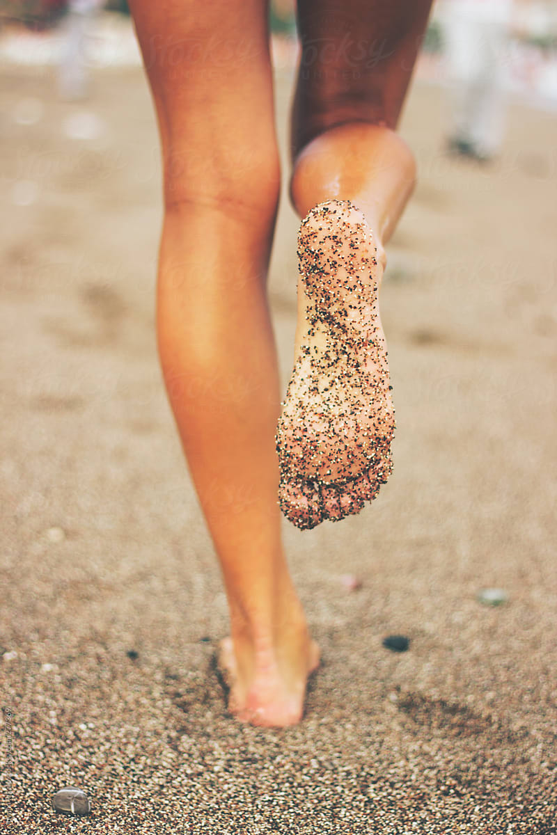 Female Feet On The Beach Covered In Sand By Stocksy Contributor