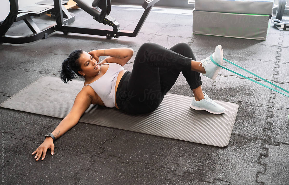 Plus Size Woman Exercise Using Resistance Band On The Mat