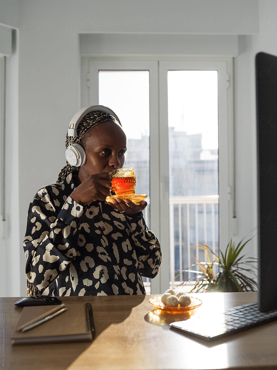Black woman enjoying tea while watching movie