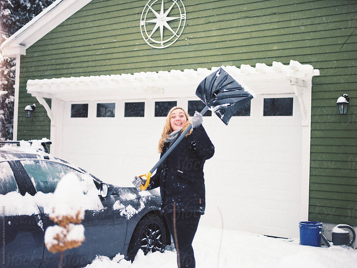 ugc of woman removing the snow around her car after a blizzard