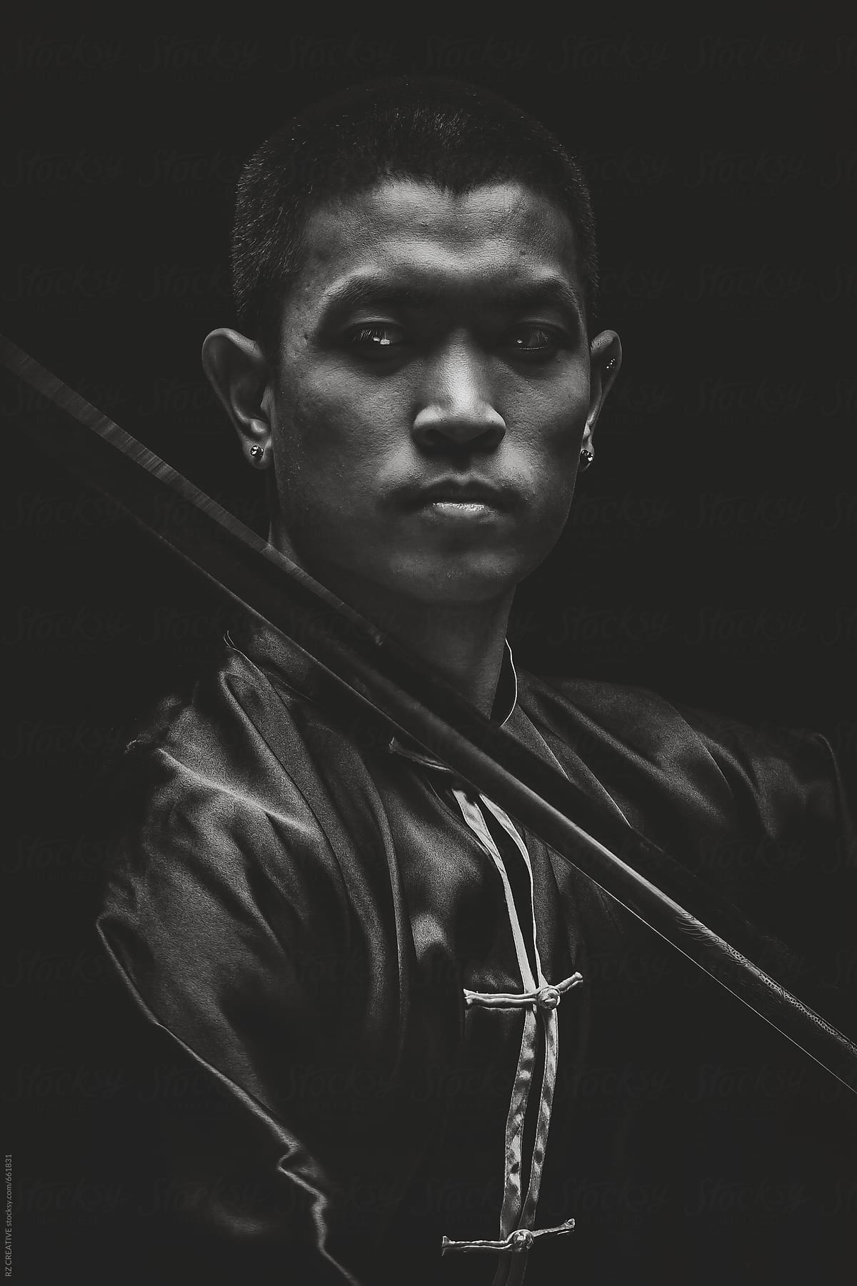 Black and white portrait of a martial artist with sword.