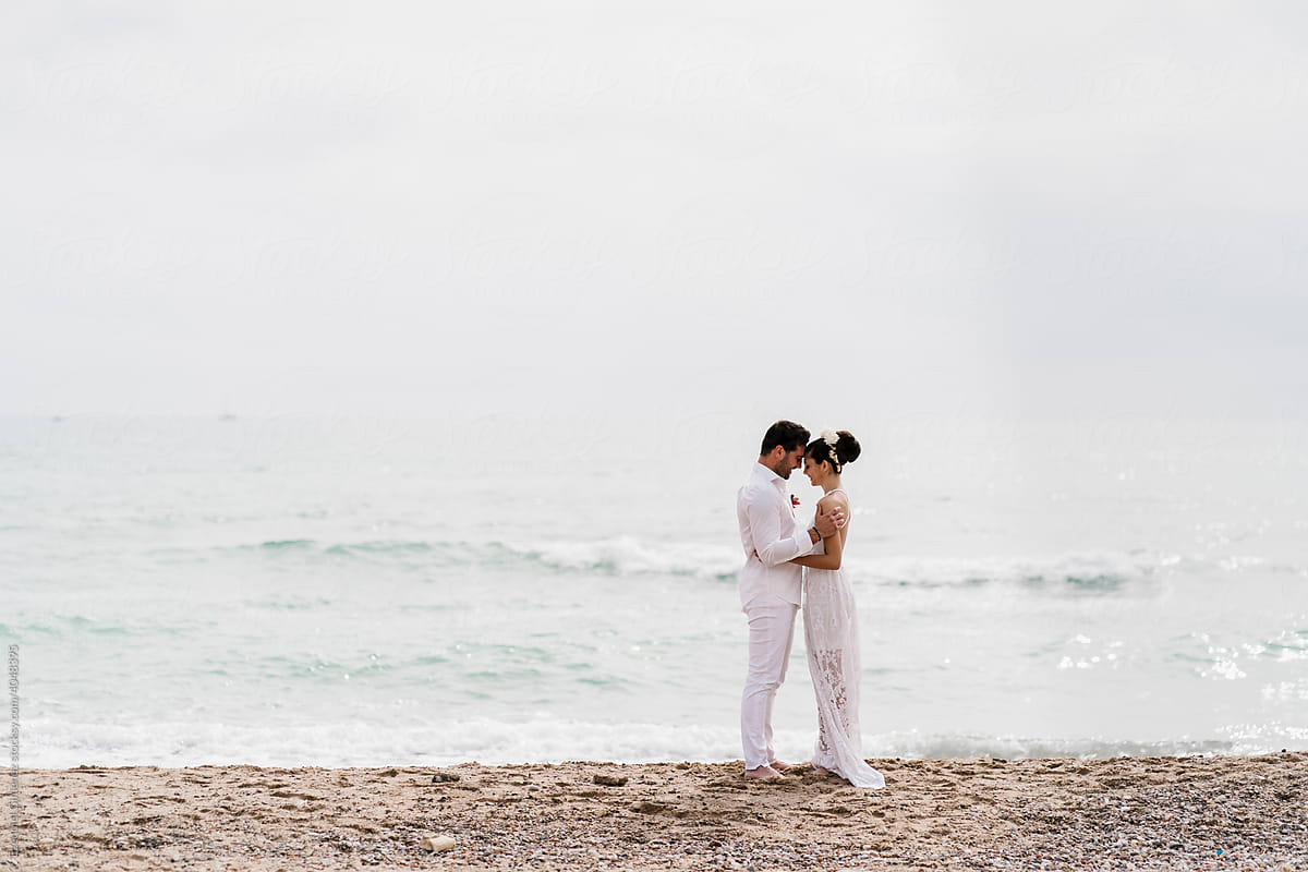 Young wedding couple embracing on the beach