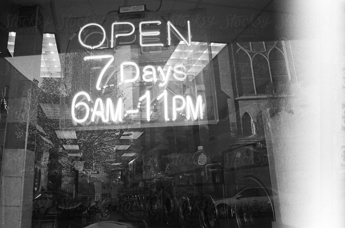 An opening hours neon sign