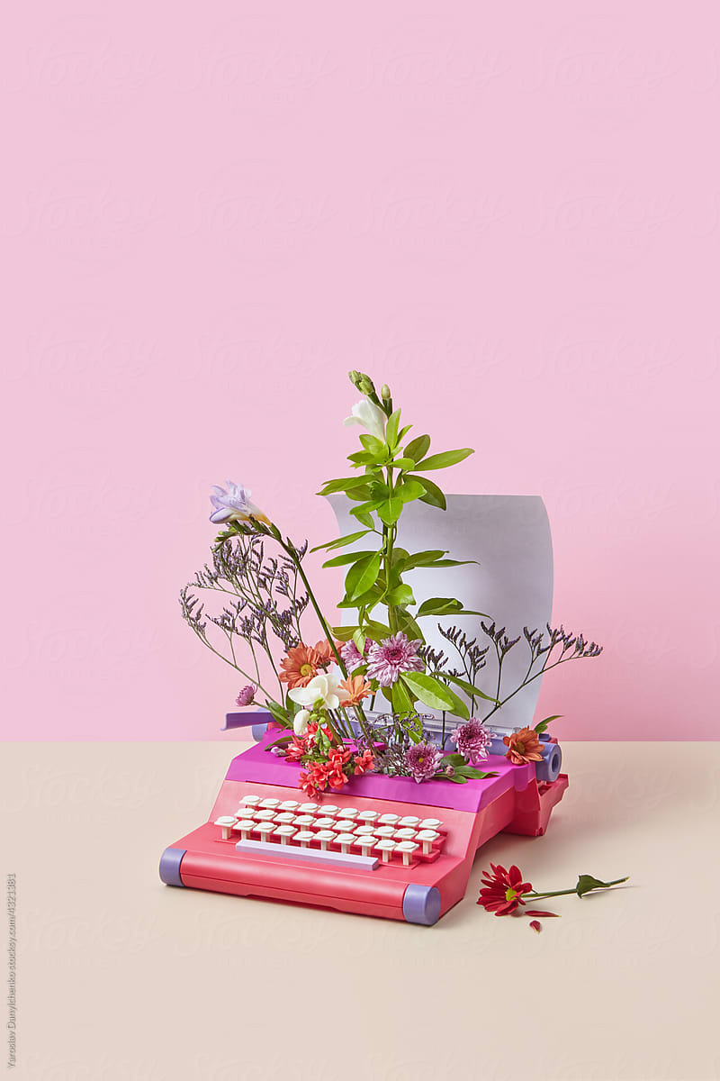 Vintage typewriter with paper and colorful flowers