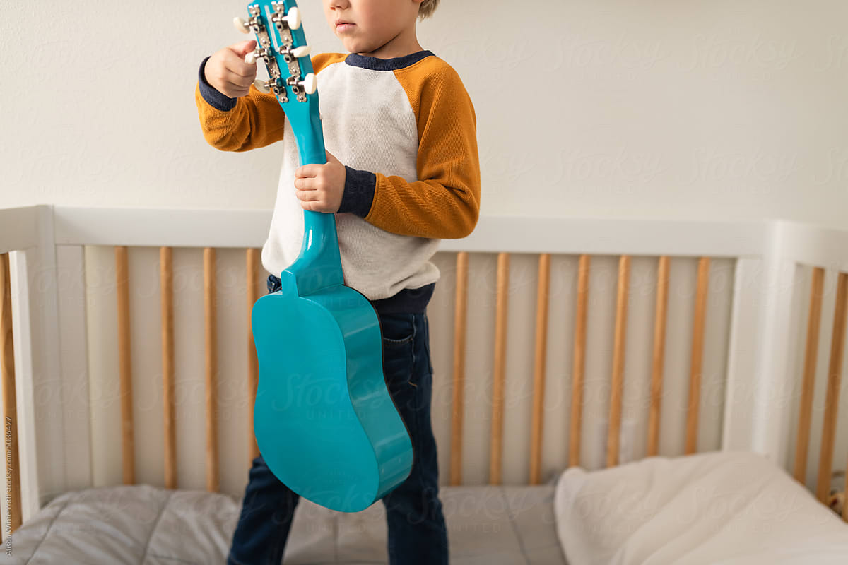 Boy tuning his guitar