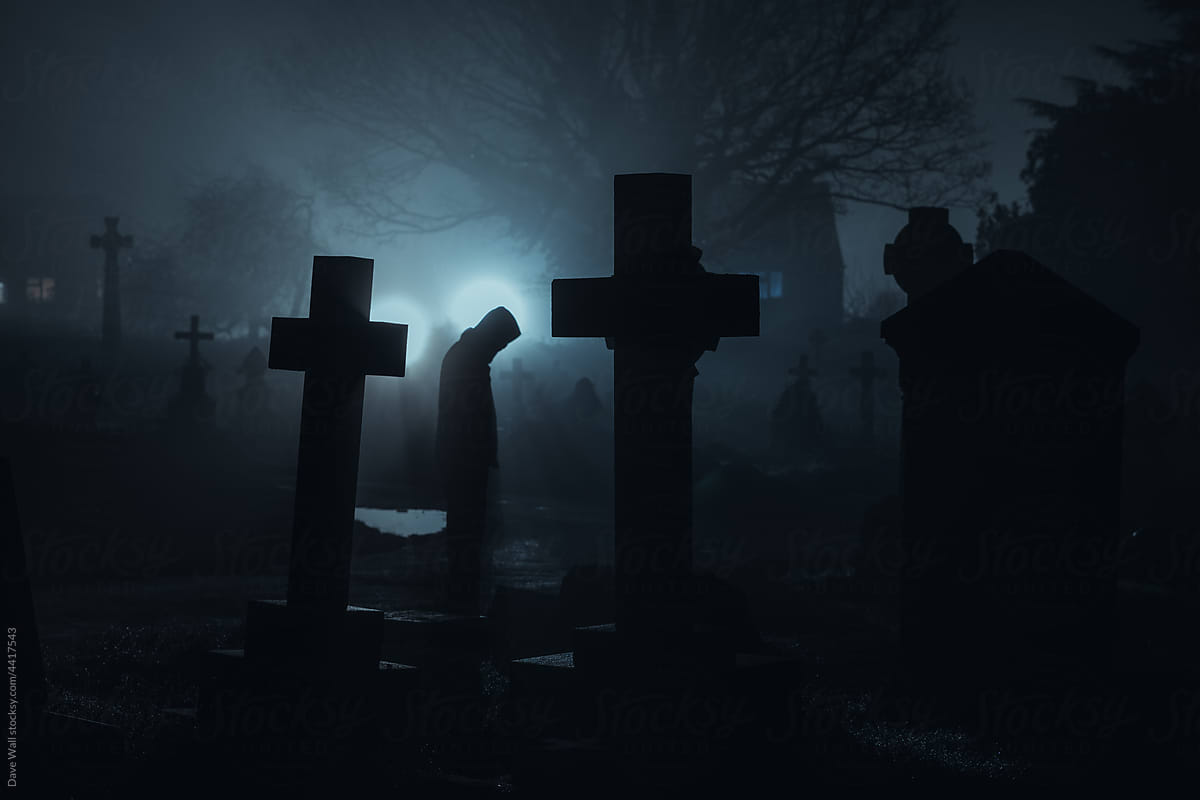 A scary hooded figure in a graveyard