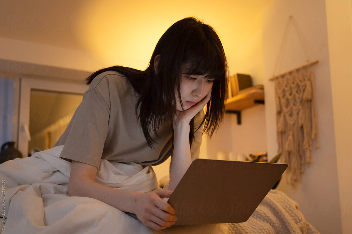 Focused Asian woman watching film on netbook