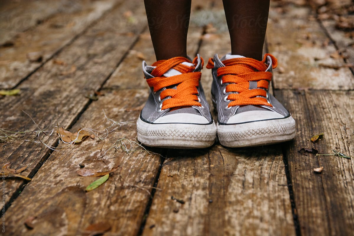 African American child in adult size tennis shoes