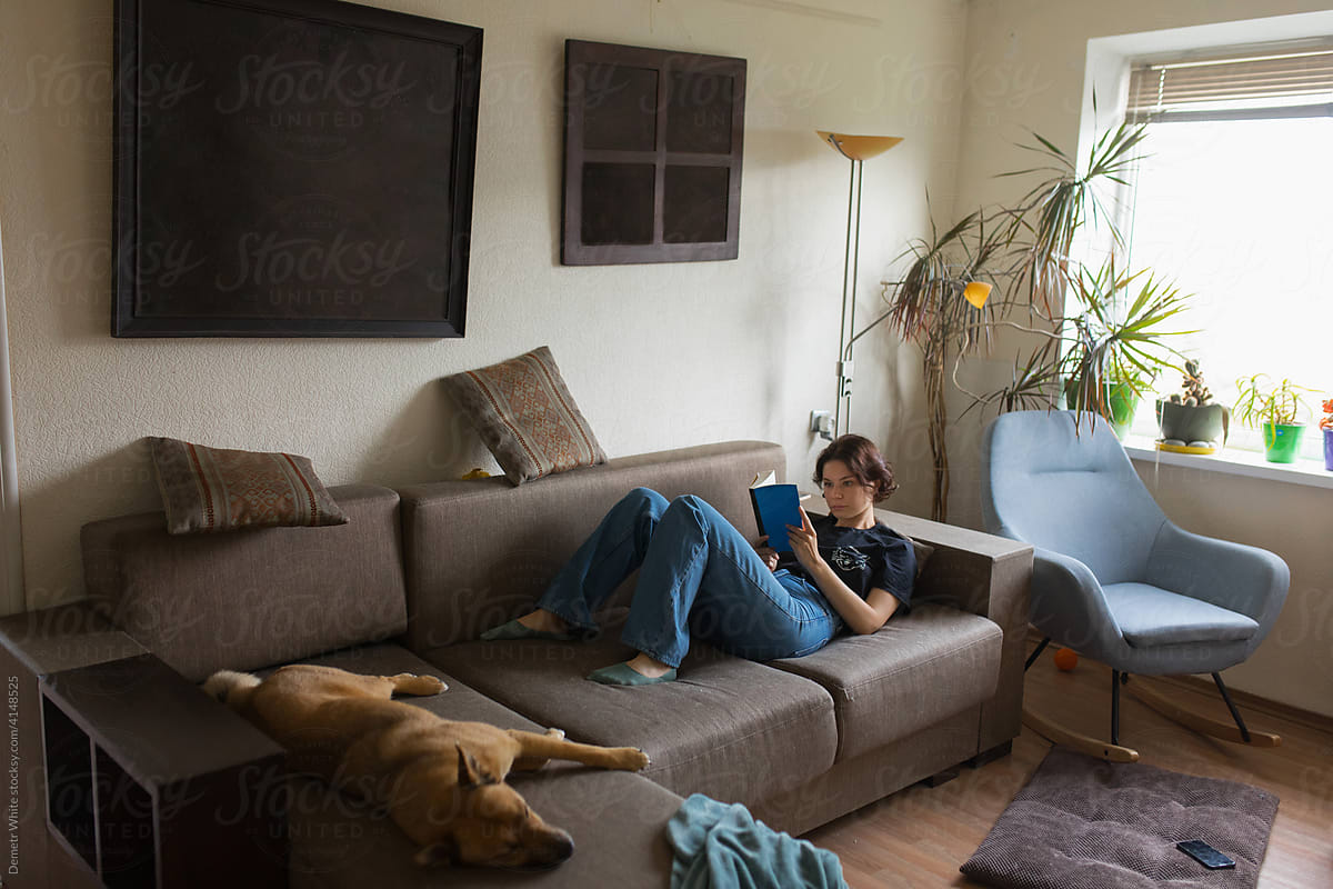 girl reading a book on the couch