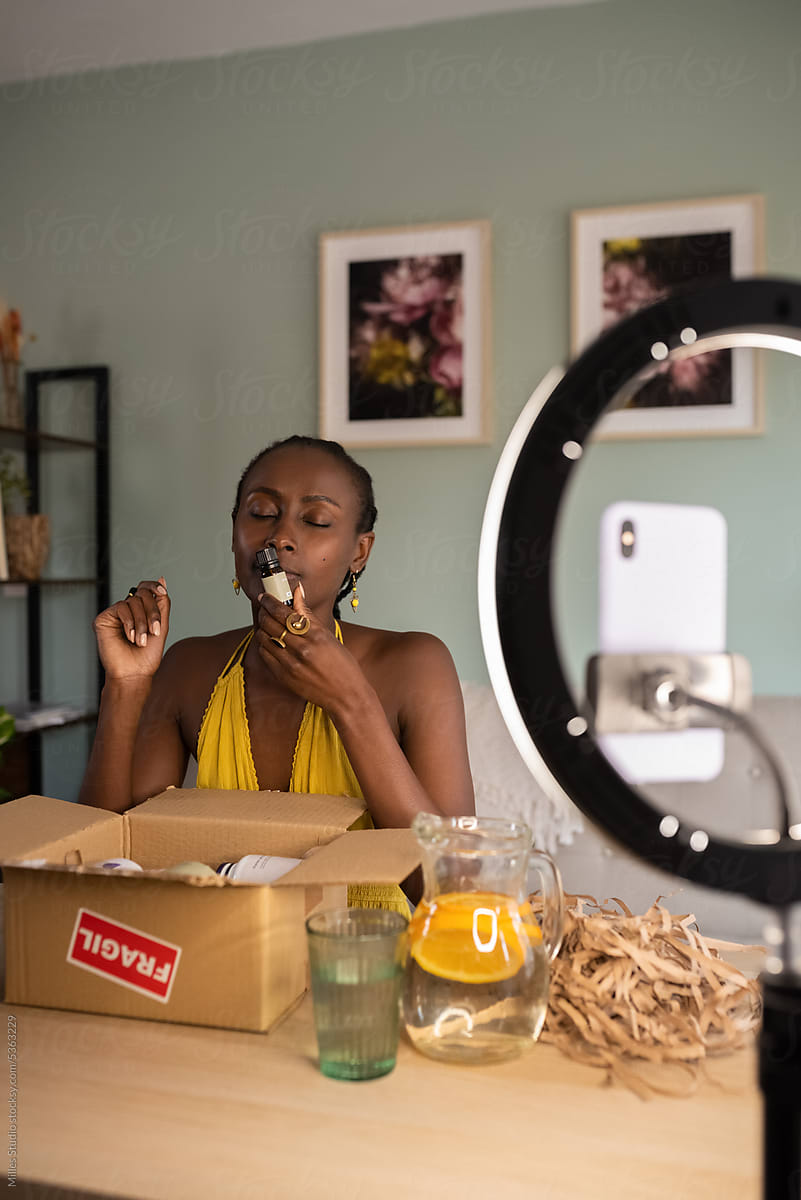 Black female wellness influencer smelling essential oil