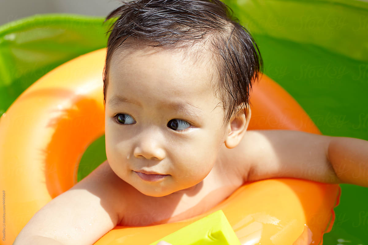 Asian kid playing in small swimming pool