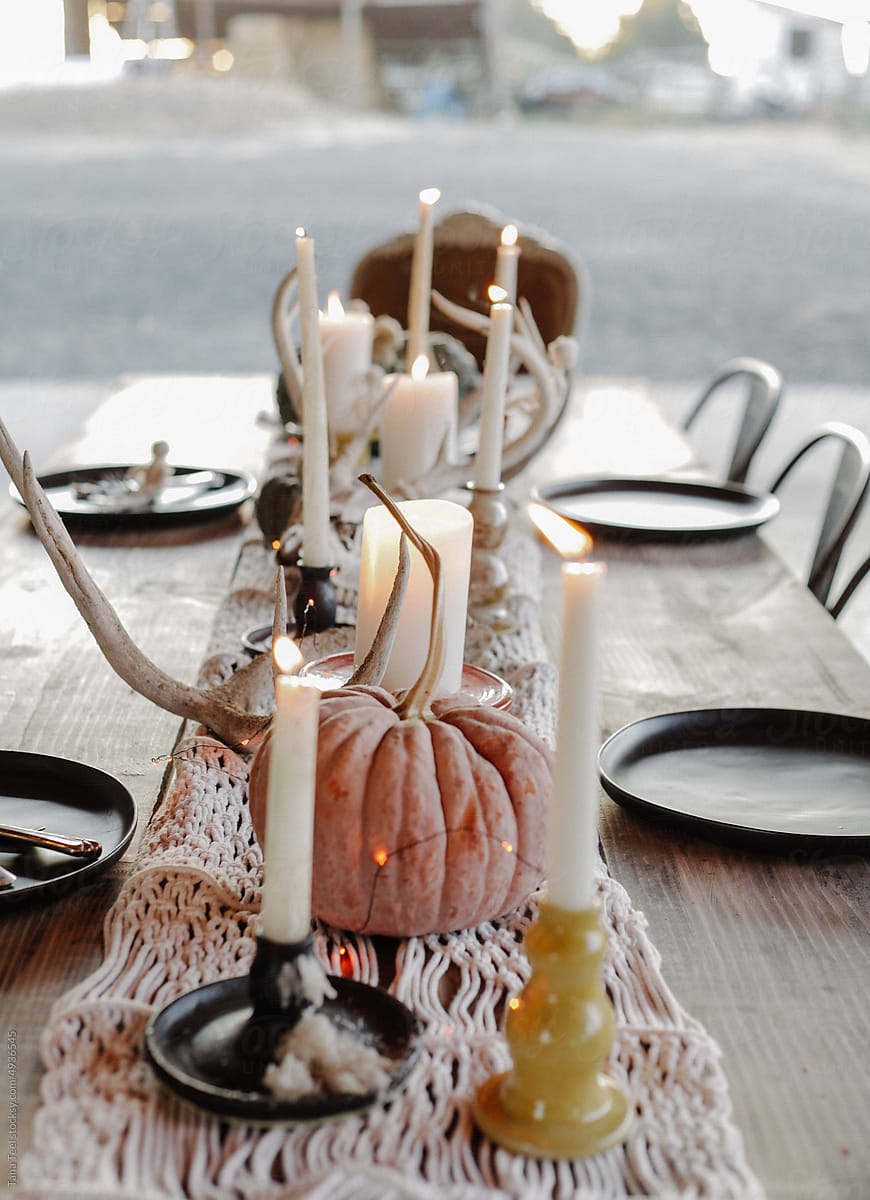 lighted candles in handmade ceramic candlesticks decorate fall table