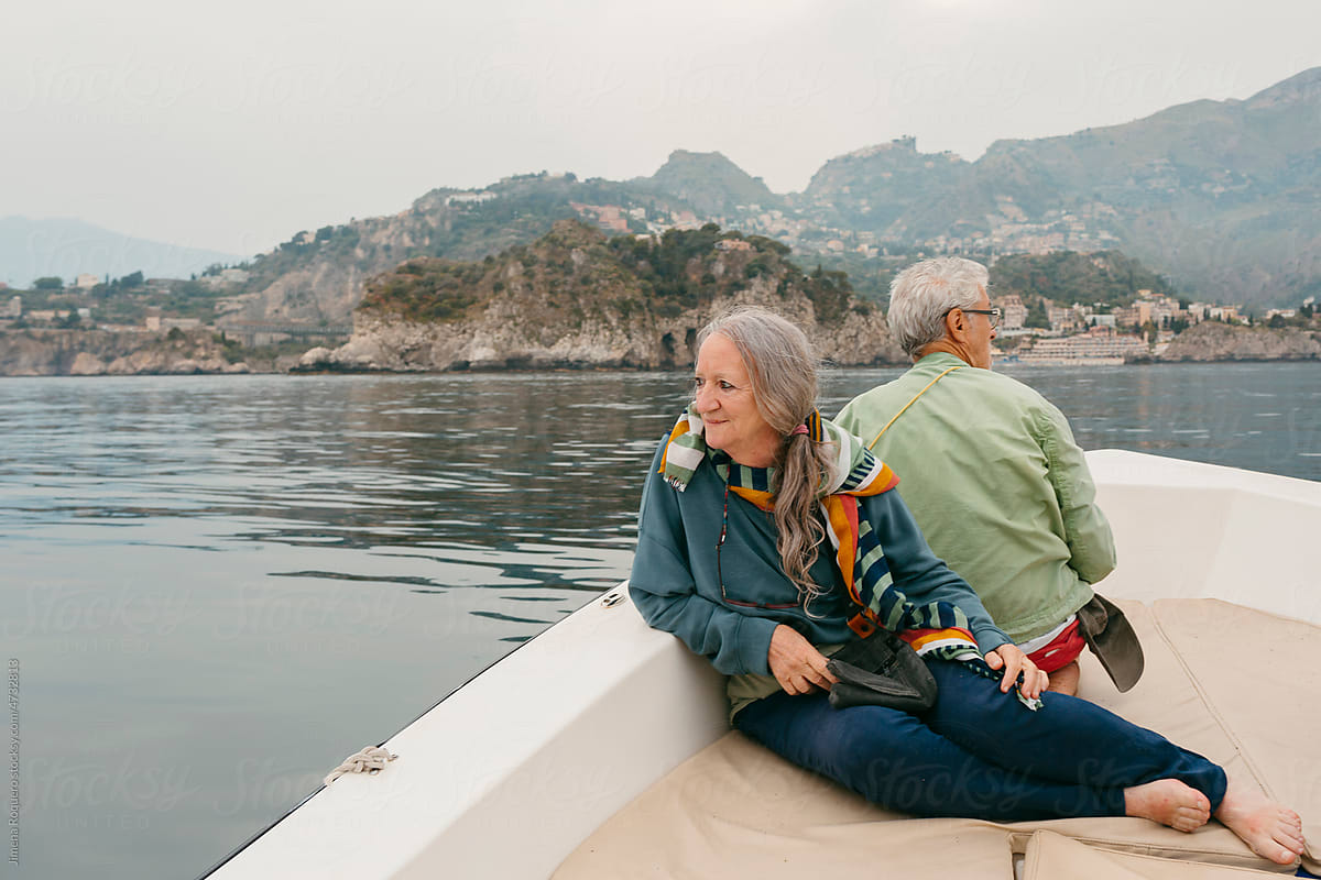 Senior couple in expedition on motorboat sailing the Sicilian coast