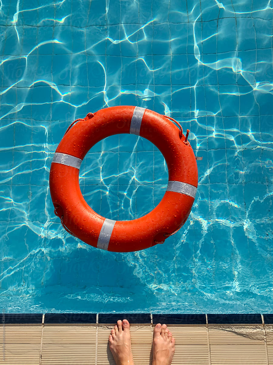travel insurance, feet and life buoy in swimming pool