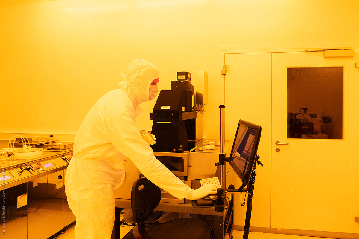 Scientist Using Computer In Yellow Light Clean Room