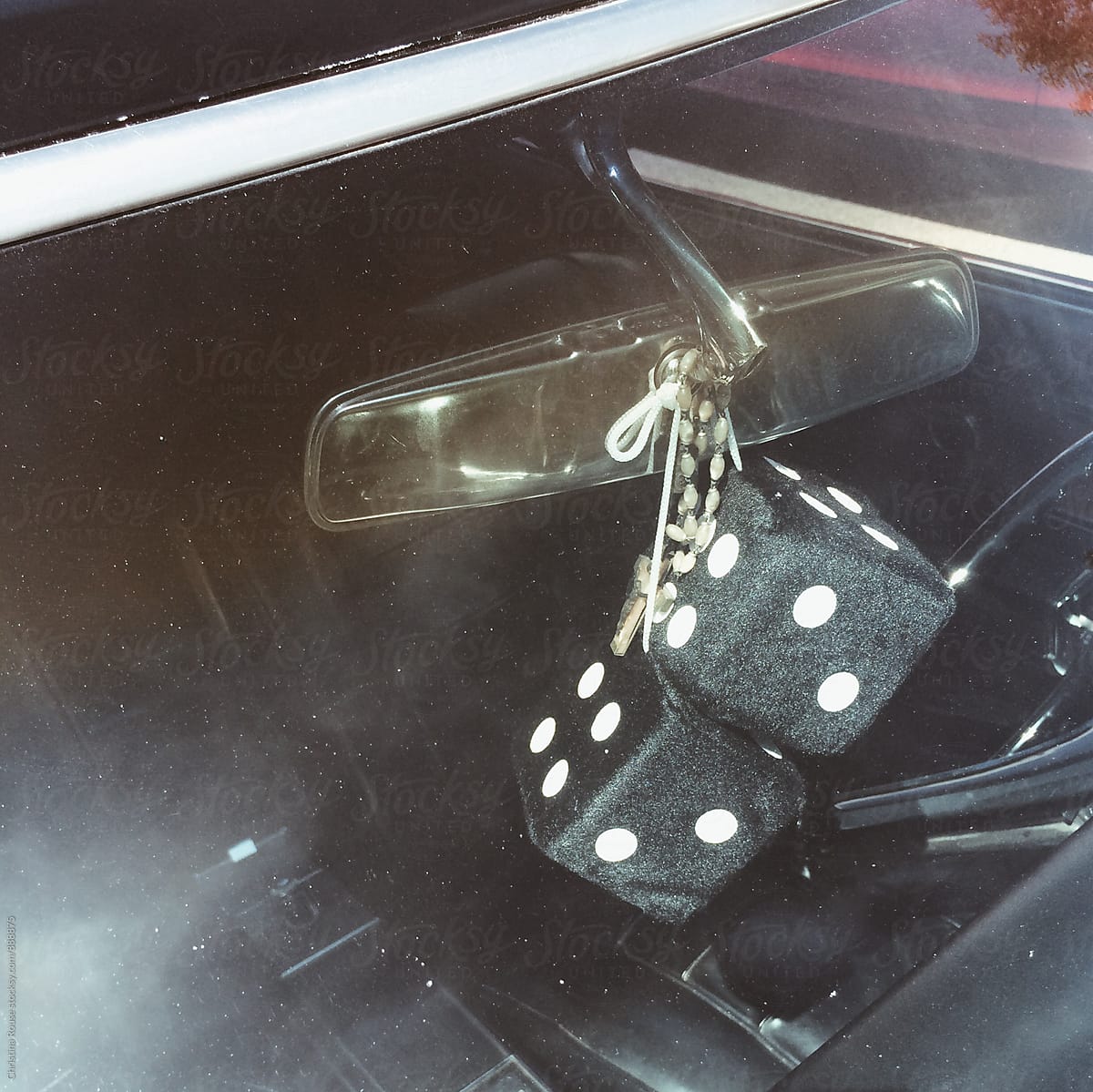 Fuzzy dice hanging from a car\'s rear view mirror