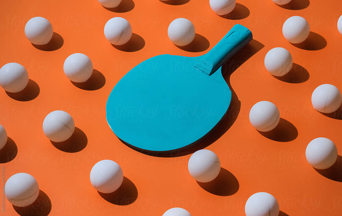 Blue ping pong racket with balls.