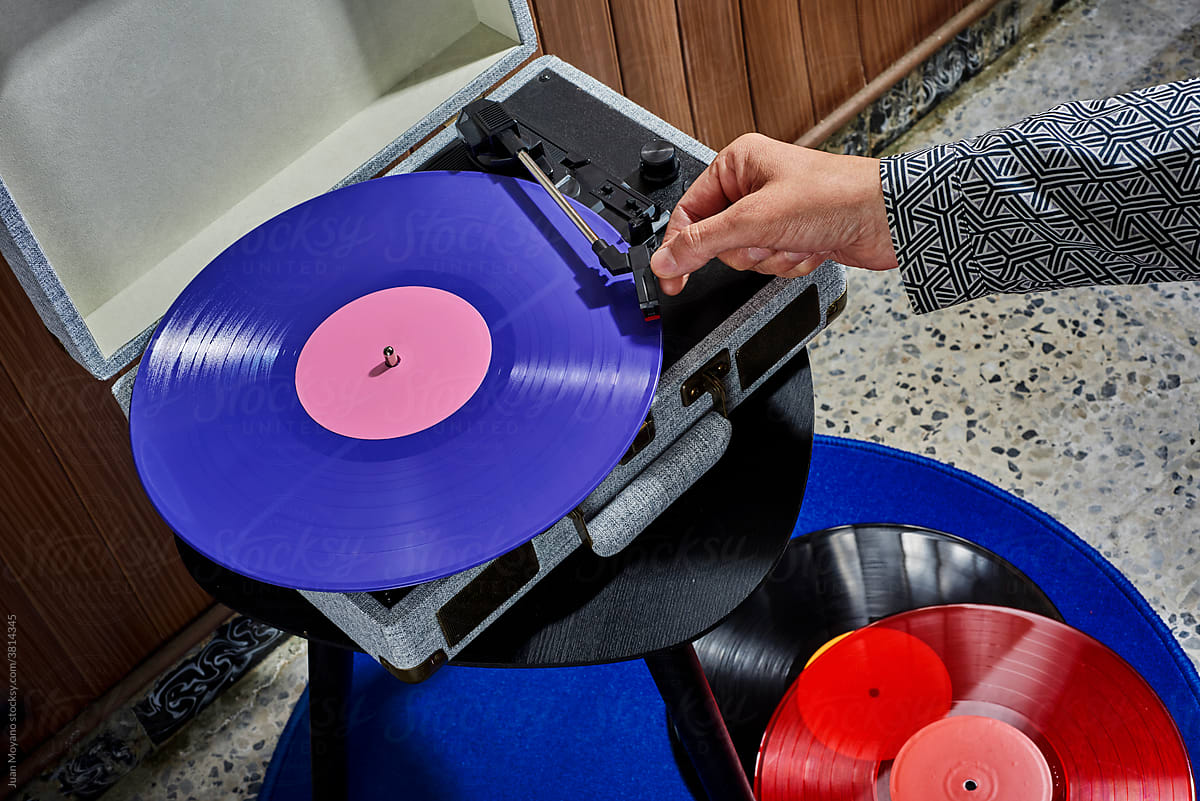 man about to play a violet disc in a turntable